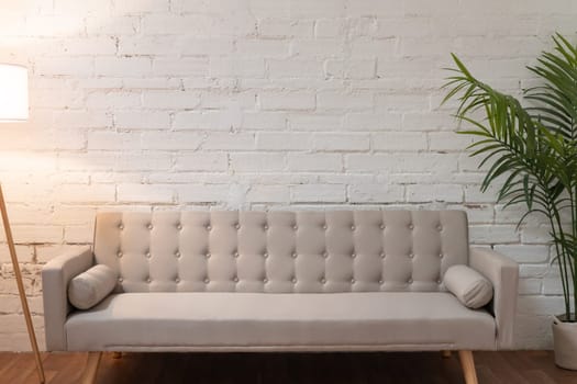 Sofa over white brick wall with copy space. High quality photo