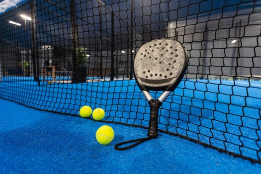 paddle tennis racket and balls on the blue paddle court. High quality photo