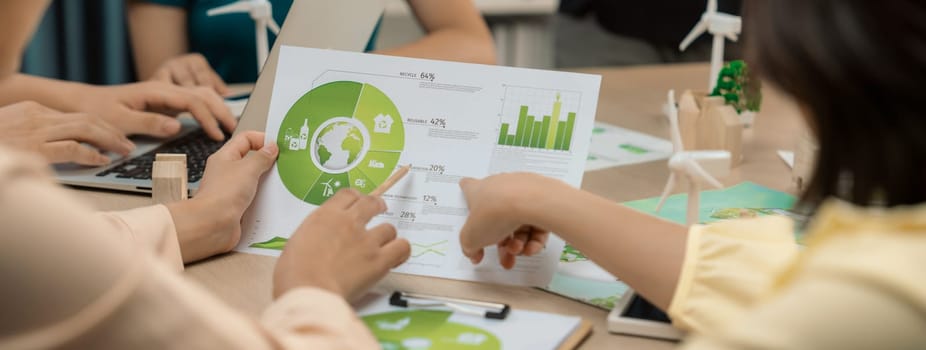 Professional businessman interested in invested in green businesses when he see rising graph on table with environmental document and wooden block scatter around. Closeup. Focus on hand. Delineation.