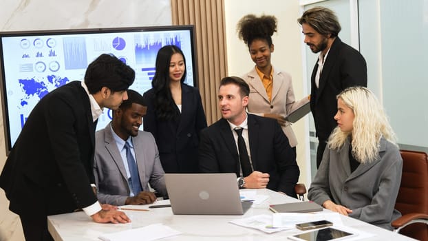 Analyst team utilizing BI Fintech to analyze financial data at table in ornamented meeting room. Businesspeople analyzing BI dashboard power for business insight and strategic marketing planning.