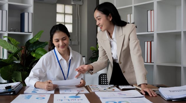 Team businesswomen discussing financial reports in office.