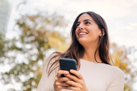 caucasian woman smiling happy using her mobile phone, concept of technology of communication and modern lifestyle, copy space for text