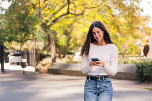 caucasian woman smiling happy using her mobile phone, concept of technology of communication and modern lifestyle, copy space for text