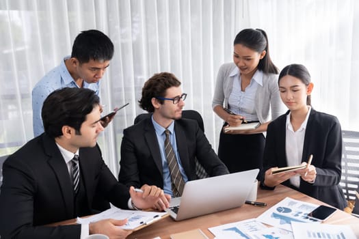 Diverse group of business analyst team analyzing financial data report paper on office table. Chart and graph dashboard by business intelligence analysis for strategic marketing planning Meticulous