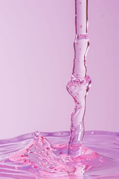 Pink liquid pouring into glass with purple and pink background, conceptual image of beauty and elegance