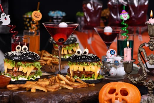 Monster Burger. Black bun, juicy beef cutlet, lettuce, onion, tomato and cheese in the shape of teeth, mozzarella eyes with olives. Definitely a pick-me-up and a perfect Halloween party appetizer.