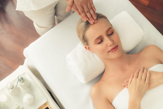 Panorama top view of woman enjoying relaxing anti-stress head massage and pampering facial beauty skin recreation leisure in dayspa modern light ambient at luxury resort or hotel spa salon. Quiescent