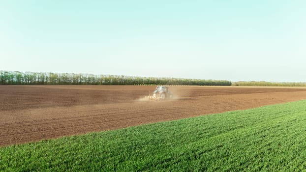 Tractor plows field in the spring. sowing the crop.