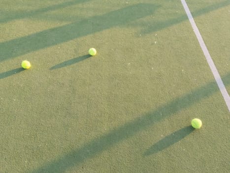 Tennis balls on a outdoor green hard court. High quality photo