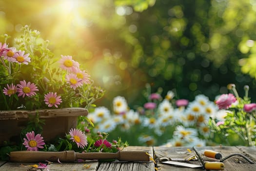 Colorful flowers and garden tools arranged on a wooden table, set against a blurred natural background.