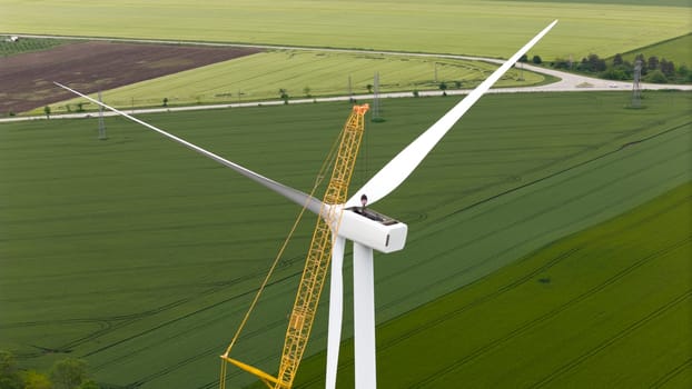carbon neutral electricity power. Aerial view of green meadows with renewable energy wind turbine