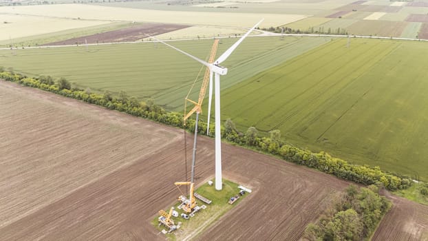 carbon neutral electricity power. Aerial view of green meadows with renewable energy wind turbine