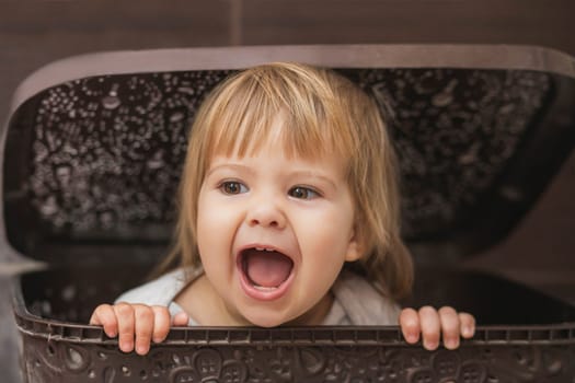 adorable baby hiding in a laundry basket.