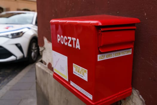 Warsaw, Poland - August 6, 2023: A red mailbox is mounted on the side of a wall in the city of Warsaw, Poland.