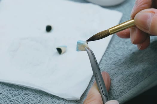 Dental Technician Working With Ceramic Crowns In Dental Laboratory. Close-up