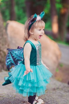 adorable baby in a dragon costume in the garden.