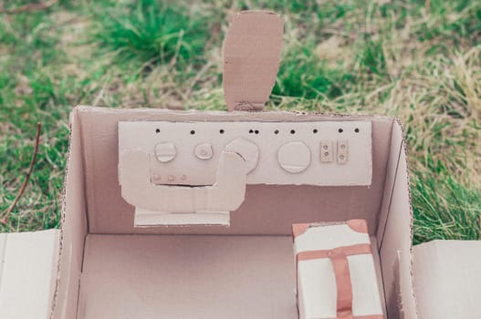 Toy cardboard plane in the field. Focus on the steering wheel.