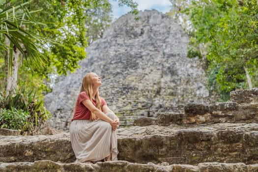 Woman tourist at Coba, Mexico. Ancient mayan city in Mexico. Coba is an archaeological area and a famous landmark of Yucatan Peninsula. Cloudy sky over a pyramid in Mexico.