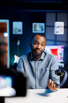 Professional camera capturing footage of content creator filming tech tutorial on how to do stereo Bluetooth headphones maintenance, teaching viewers about fixing broken audio device