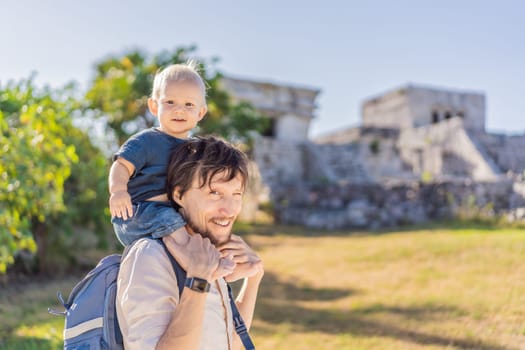 Father and son tourists enjoying the view Pre-Columbian Mayan walled city of Tulum, Quintana Roo, Mexico, North America, Tulum, Mexico. El Castillo - castle the Mayan city of Tulum main temple.