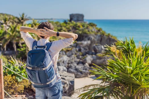 Man tourist enjoying the view Pre-Columbian Mayan walled city of Tulum, Quintana Roo, Mexico, North America, Tulum, Mexico. El Castillo - castle the Mayan city of Tulum main temple.