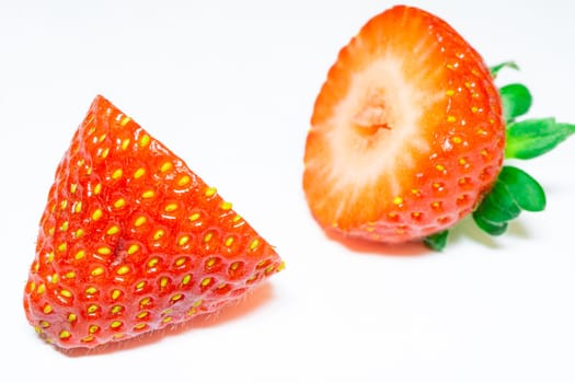 Close up from a strawberry cut in half, on a white background.