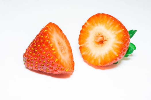 Close up from a strawberry cut in half, on a white background.