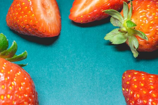 Peaces of fresh strawberries on a blue background.