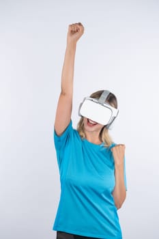 Caucasian happy girl wearing VR glasses and making winner gesture. Skilled woman celebrate while winning game by using VR headsets and standing at pink background. Technology innovation. Contraption.