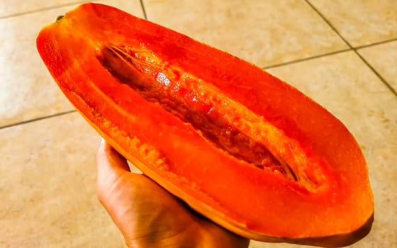 Half papaya in hand with background in Playa del Carmen Quintana Roo Mexico.