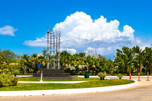 Artistic fountain well with metal figures in a tropical setting in Playa del Carmen Quintana Roo Mexico.