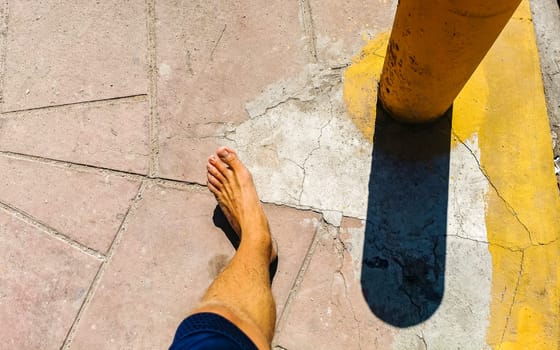 Walking on the pavement rocks stones feet barefoot in Zicatela Puerto Escondido Oaxaca Mexico.