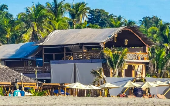 Restaurant restaurants bar bars shops hotels palms palm trees and promenades on the beach in Zicatela Puerto Escondido Oaxaca Mexico.