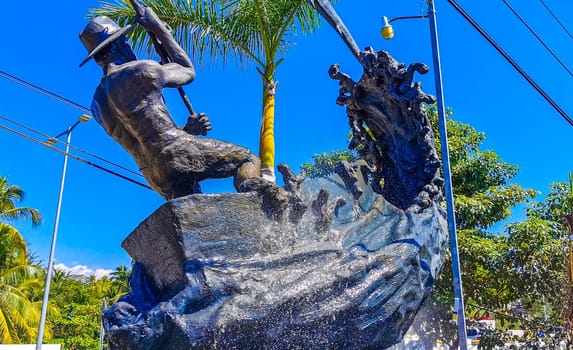 Statue sculpture angler with fish swordfish fountain in Zicatela Puerto Escondido Oaxaca Mexico.