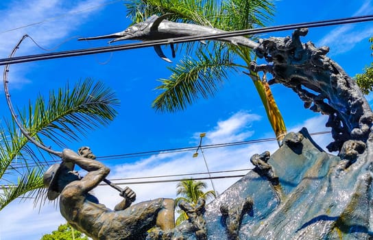 Statue sculpture angler with fish swordfish fountain in Zicatela Puerto Escondido Oaxaca Mexico.