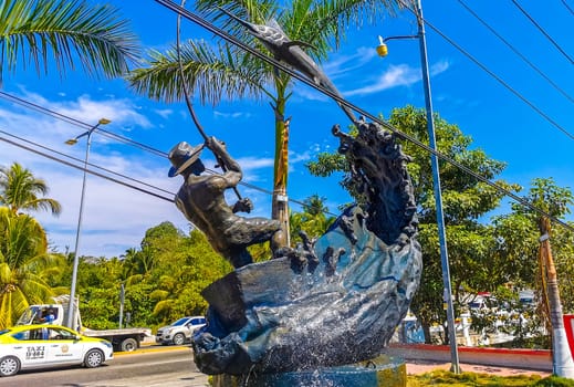 Statue sculpture angler with fish swordfish fountain in Zicatela Puerto Escondido Oaxaca Mexico.