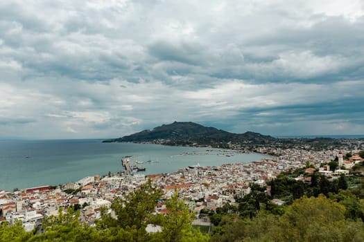 Beautiful panoramic view of the capital Zakynthos with the mountain and the Ionian sea on a gloomy, cloudy summer day, close-up side view.
