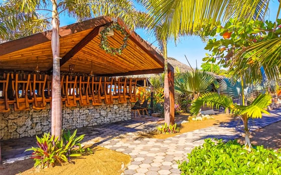 Restaurant restaurants bar bars shops hotels palms palm trees and promenades on the beach in Zicatela Puerto Escondido Oaxaca Mexico.