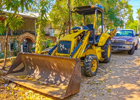 Yellow excavator with shovel in Zicatela Puerto Escondido Oaxaca Mexico.