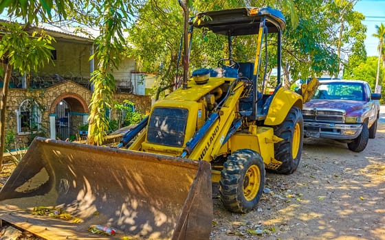 Yellow excavator with shovel in Zicatela Puerto Escondido Oaxaca Mexico.