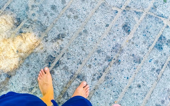 Walking on the pavement rocks stones feet barefoot in Zicatela Puerto Escondido Oaxaca Mexico.