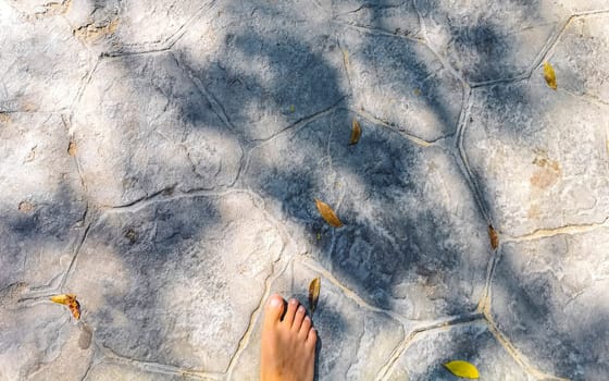 Walking on the pavement rocks stones feet barefoot in Zicatela Puerto Escondido Oaxaca Mexico.