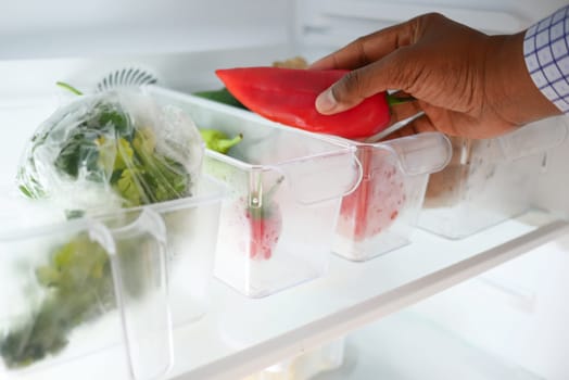 plastic containers with different fruits in a open fridge