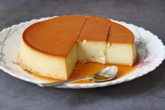 Caramel custard pudding on a plate on table ,