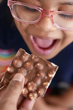 child eating dark chocolate close up .