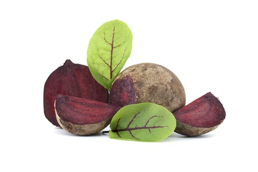 Collection of whole beetroot arranged next to slices of beetroot vegetables with their green leaves still attached isolated on a white background