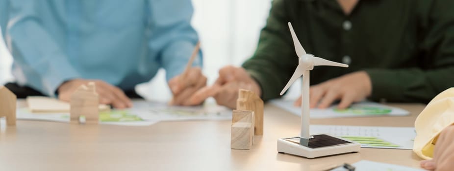 Green business meeting represented renewable energy. Skilled businesspeople discuss green business investment at table with environmental documents. Closeup. Focus on hand. Delineation.