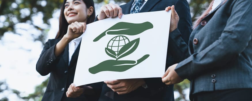 Group of business people stand united, holding eco-friendly idea and concept for environmental awareness campaign embracing eco friendly and greener environment with inspire positive change.Gyre