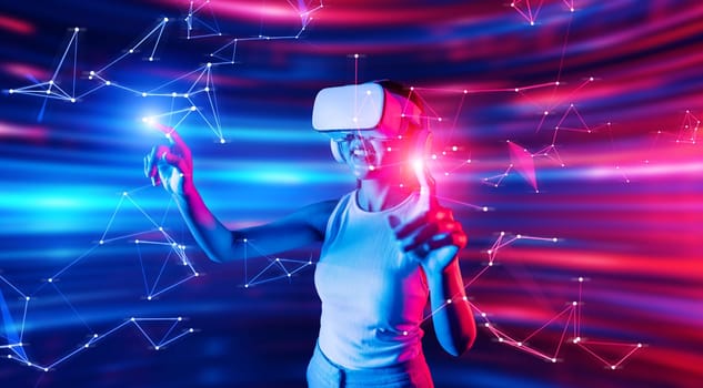 Smart female standing in cyberpunk style building in meta wear VR headset connecting metaverse, future cyberspace community technology, Woman use finger touching virtual reality object. Hallucination.