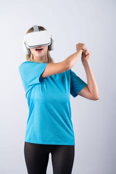 Caucasian girl playing golf and moving gesture by using VR glasses. Happy sport gamer with casual cloth playing game while wearing visual reality headset and standing at pink background. Contraption.